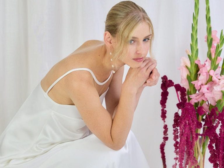 Verschiedene Brautkleidformen und Brautkleidstile. Ob Fit&Flare, Mermaid oder A-Linie - Finde dein Hochzeitskleid bei uns. Trägerloses Brautkleid mit Puffärmeln wird von einer Braut mit strenger Brautfrisur präsentiert.